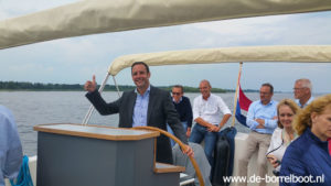 Burgemeester Harm Jan van Schaijk aan het roer op de rondvaartboot van Harderwijk.
